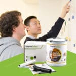 Two professionals examining Black Magnetic Paint products. Professionals reviewing paint buckets and color samples.